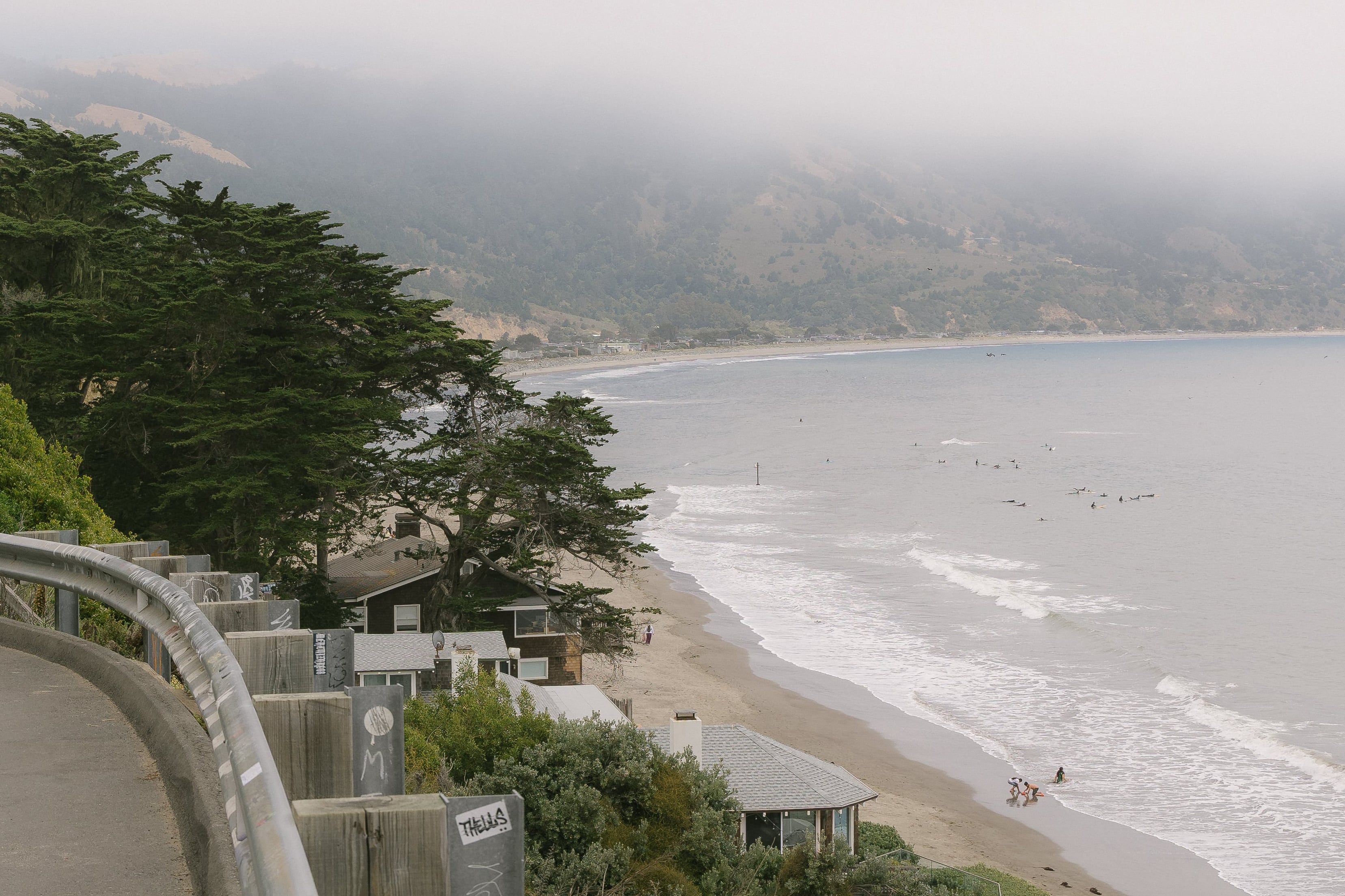 Bolinas from a road overlooking a group of surfers in the ocean